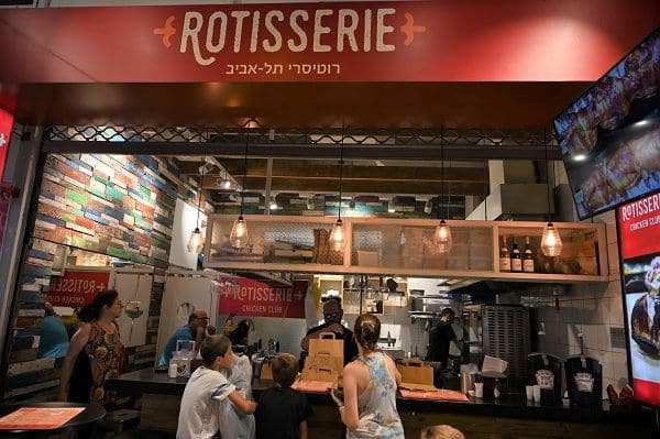 העומדים מחוץ לדוכן זוכים להריח מרחוק את הריח המפתה של הבשר הנצלה ושל תפוחי האדמה הנאפים בבסיס התנור. צילום איריס לוי